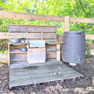 pallet wood with kitchen supplies on it next to a rain barrel
