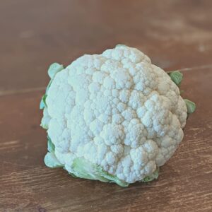 cauliflower head sitting on a farmhouse table