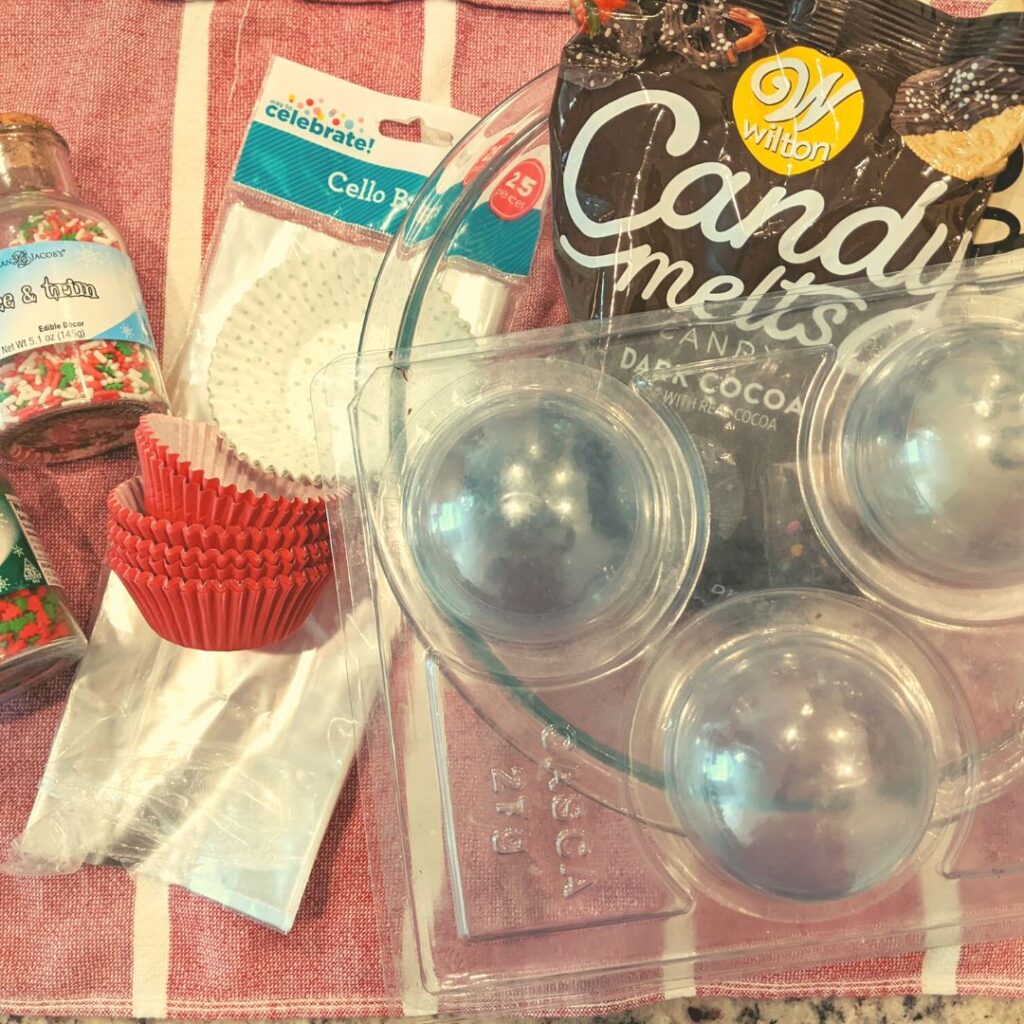 supplies to make hot chocolate bombs, mold, glass bowl, cupcake liners, cellophane bags, spirnkles.