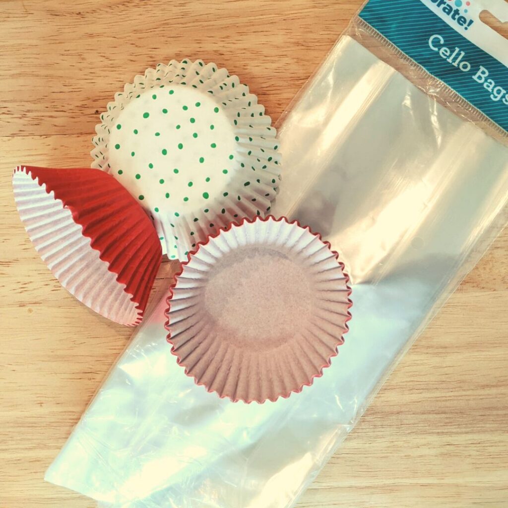 cellophane bags and cupcake liners on top wooden cutting board